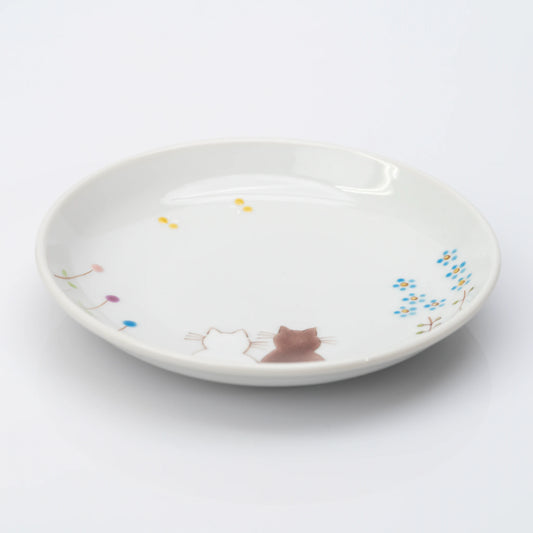 Angled view of white Kutani plate with two cats and delicate flowers