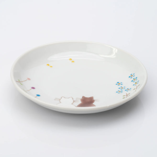 Angled view of white Kutani plate with two cats and delicate flowers