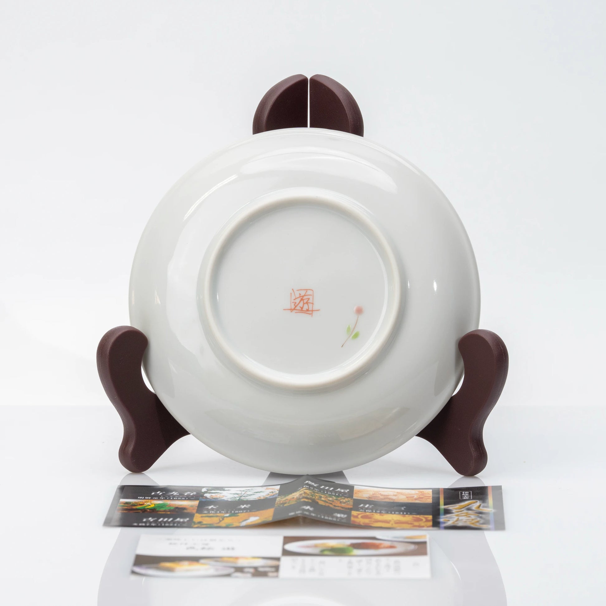 Back view of Hidamari Cats plate displayed on a stand