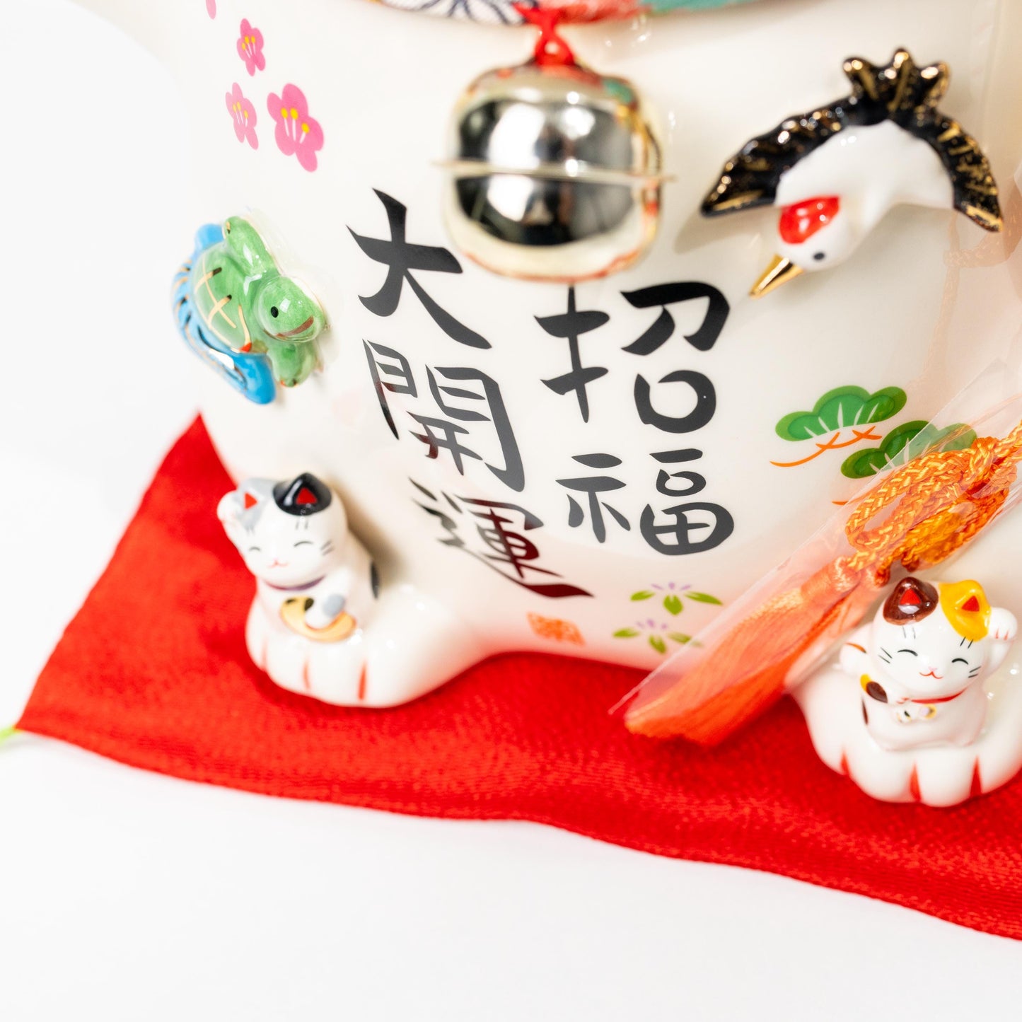 Three-quarter view of large lucky cat statue on red cushion
