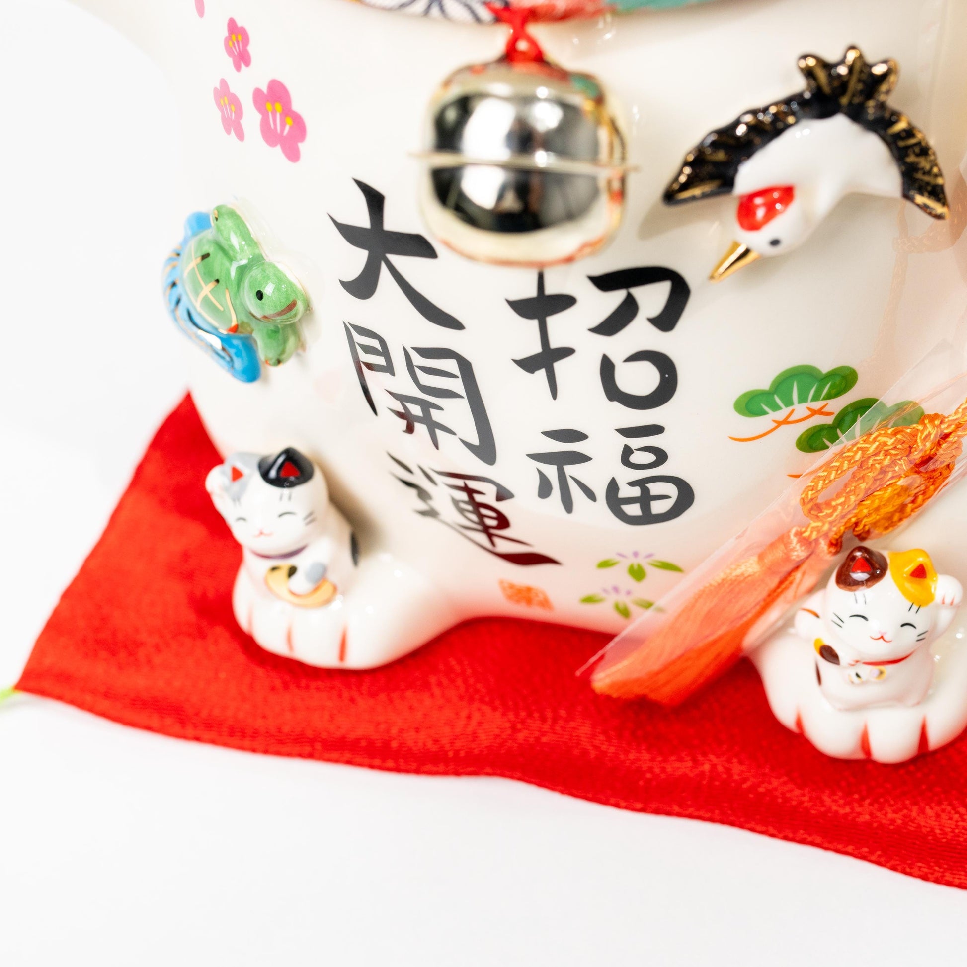 Three-quarter view of large lucky cat statue on red cushion