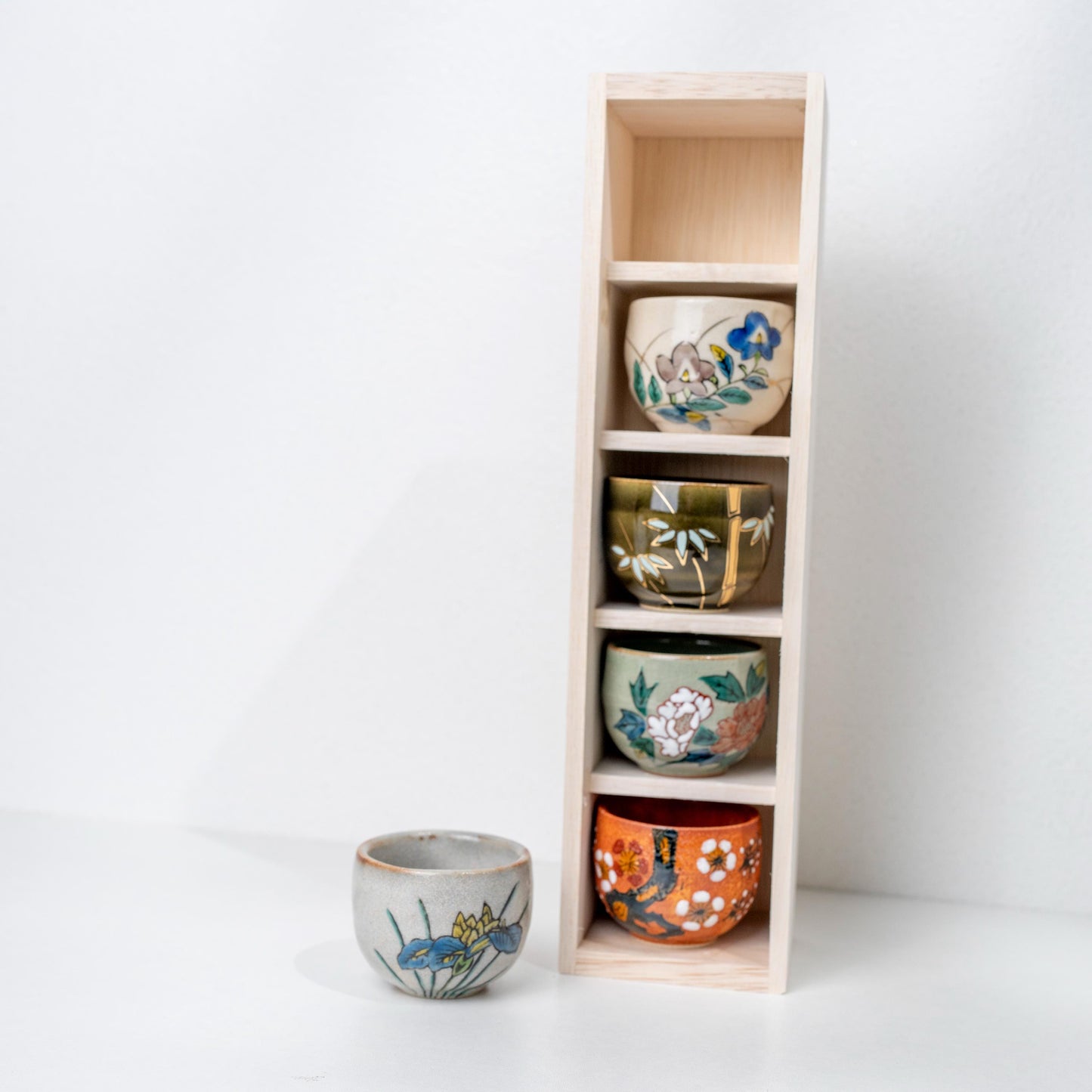 Front view of five Japanese sake cups in Kutani ware