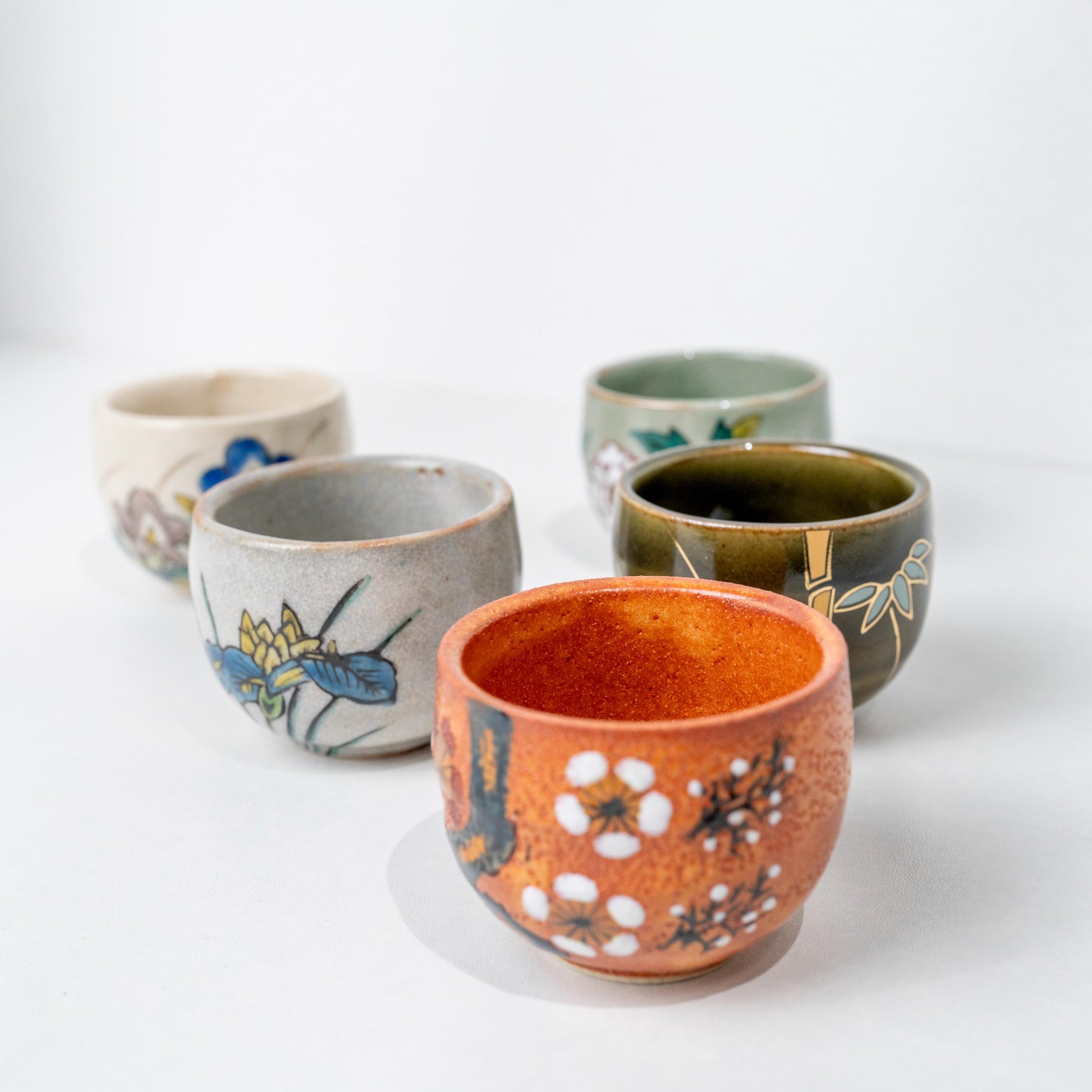 Five Kutani ochoko cups in assorted floral designs