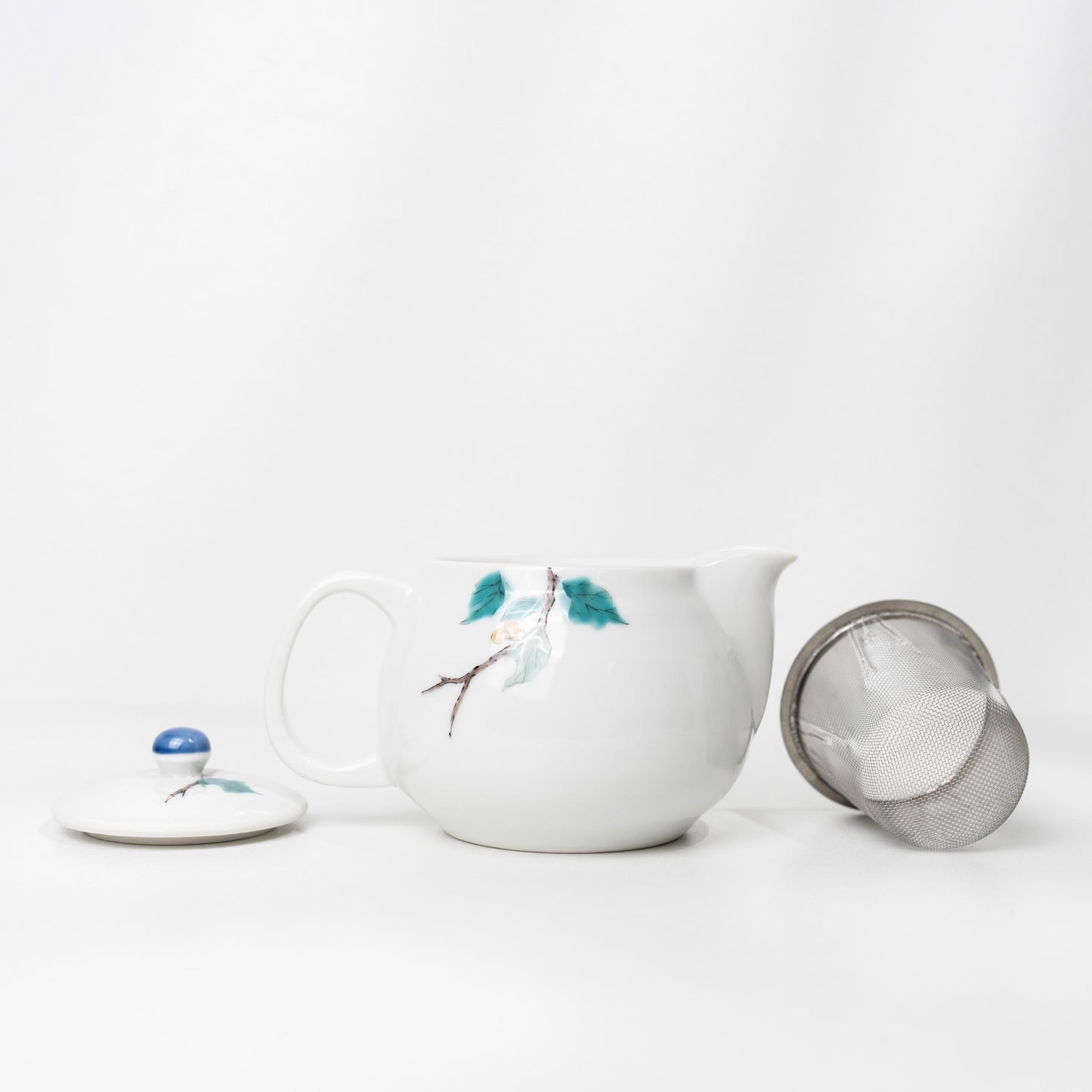 Angled view of Kutani bird teapot with blue lid knob