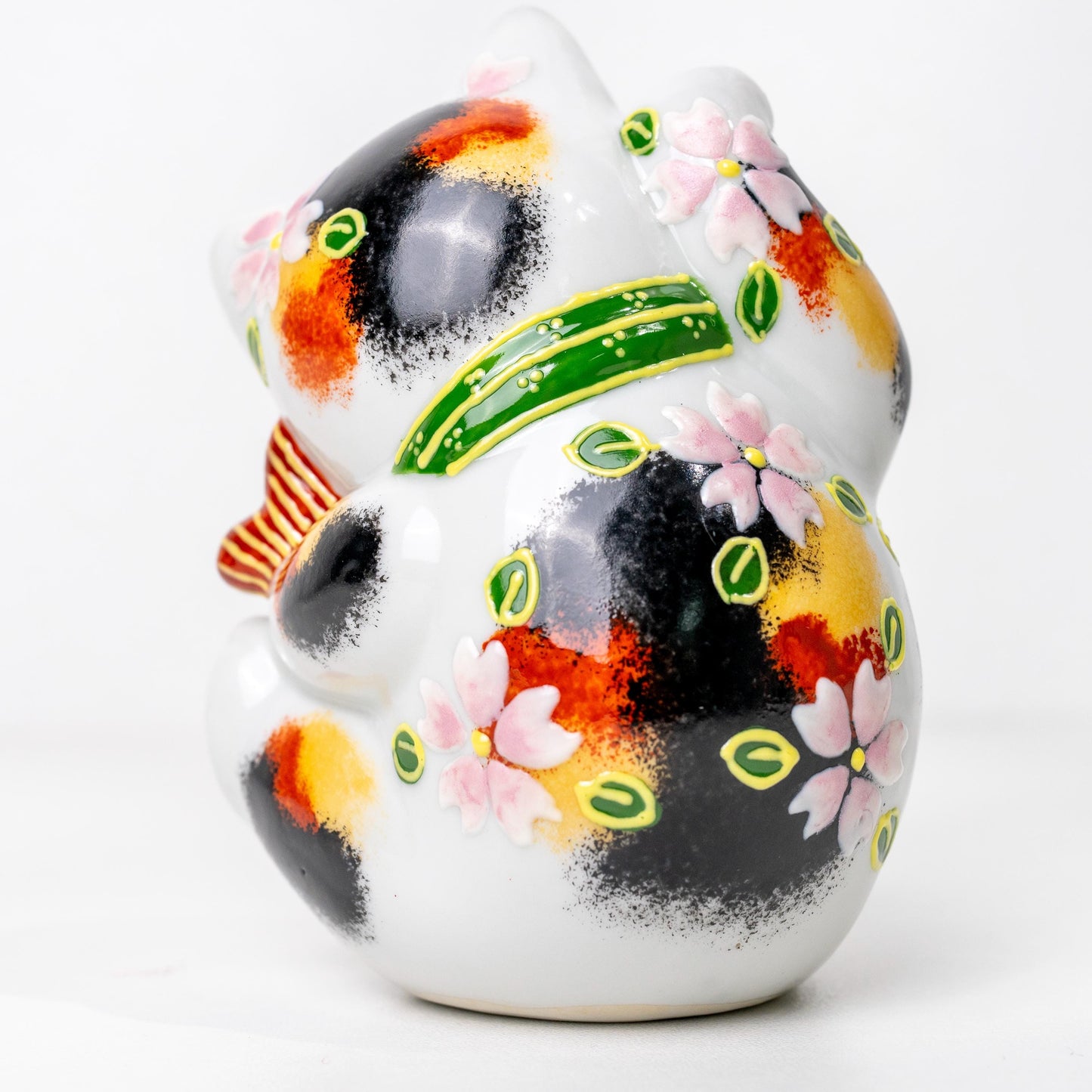 Three-quarter angle of Japanese lucky cat with red sea bream