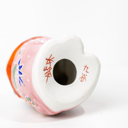 Underside of Kutani porcelain lucky cat showing base opening