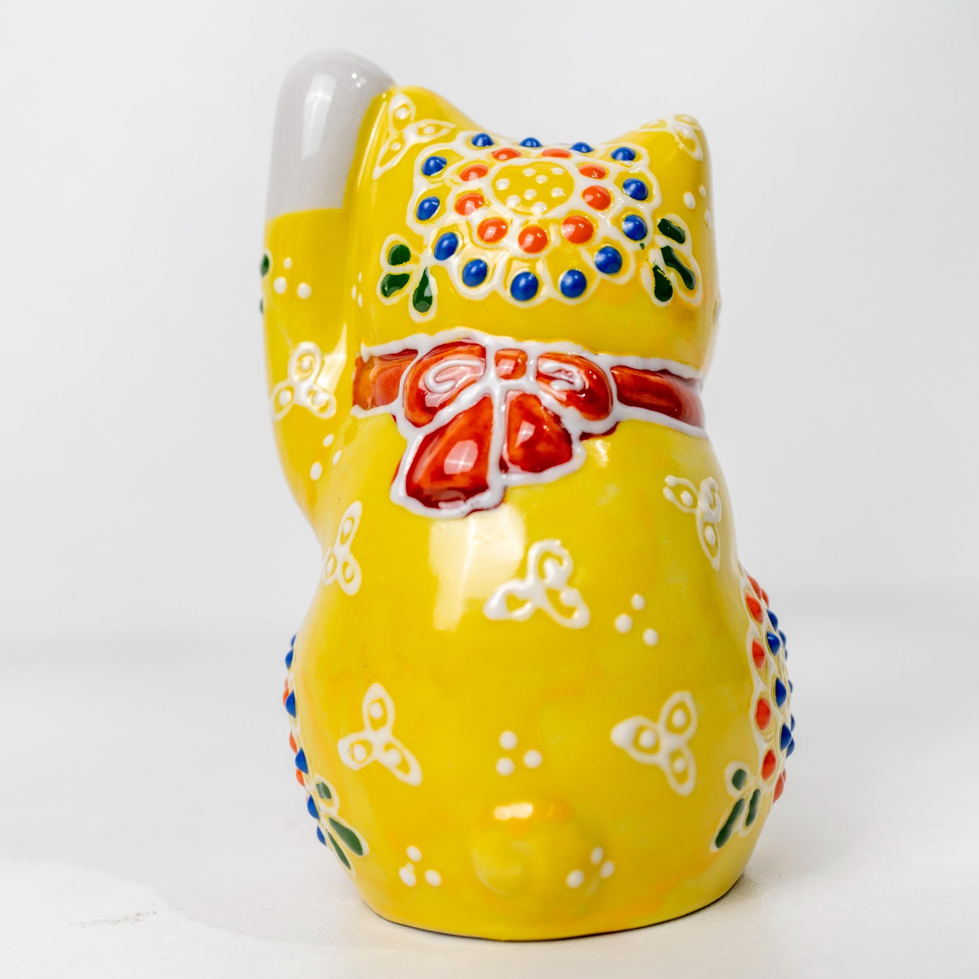 Back detail of ceramic yellow lucky cat figurine