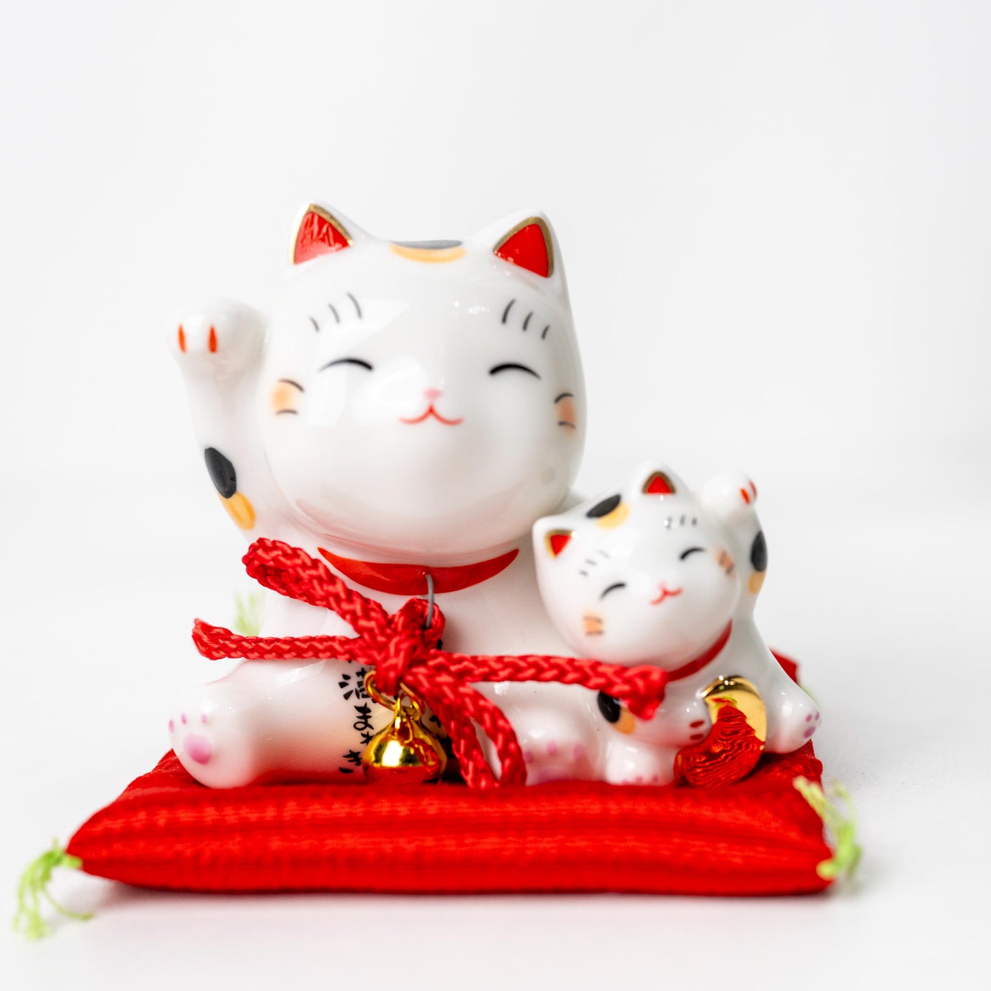 Mother and kitten Maneki Neko figurine on red cushion