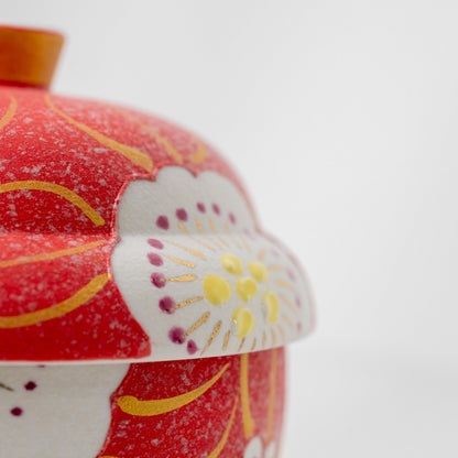 Close-up of the cherry blossom motif on a red Arita lidded bowl