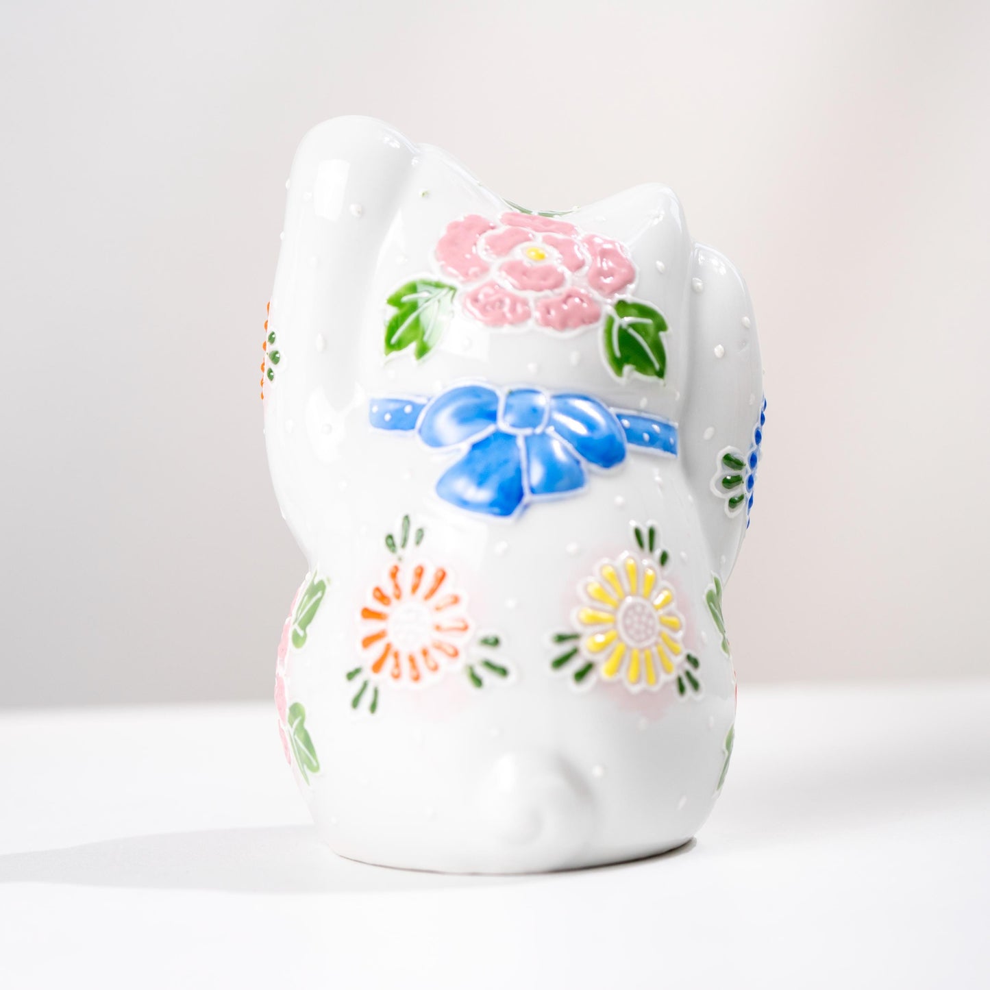 Side view of floral Kutani lucky cat figurine