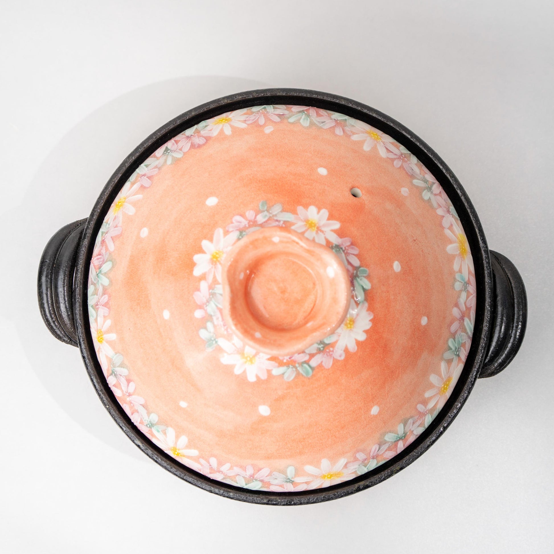Angled view of pink floral Japanese hot pot in earthenware