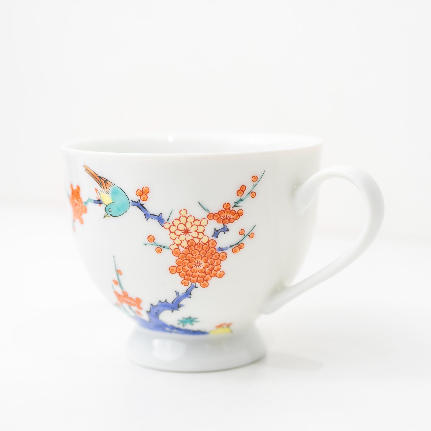 Front view of Arita bird and plum blossom cup and saucer set on white background