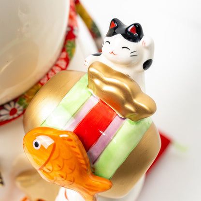Close-up of painted ornament held by the lucky cat