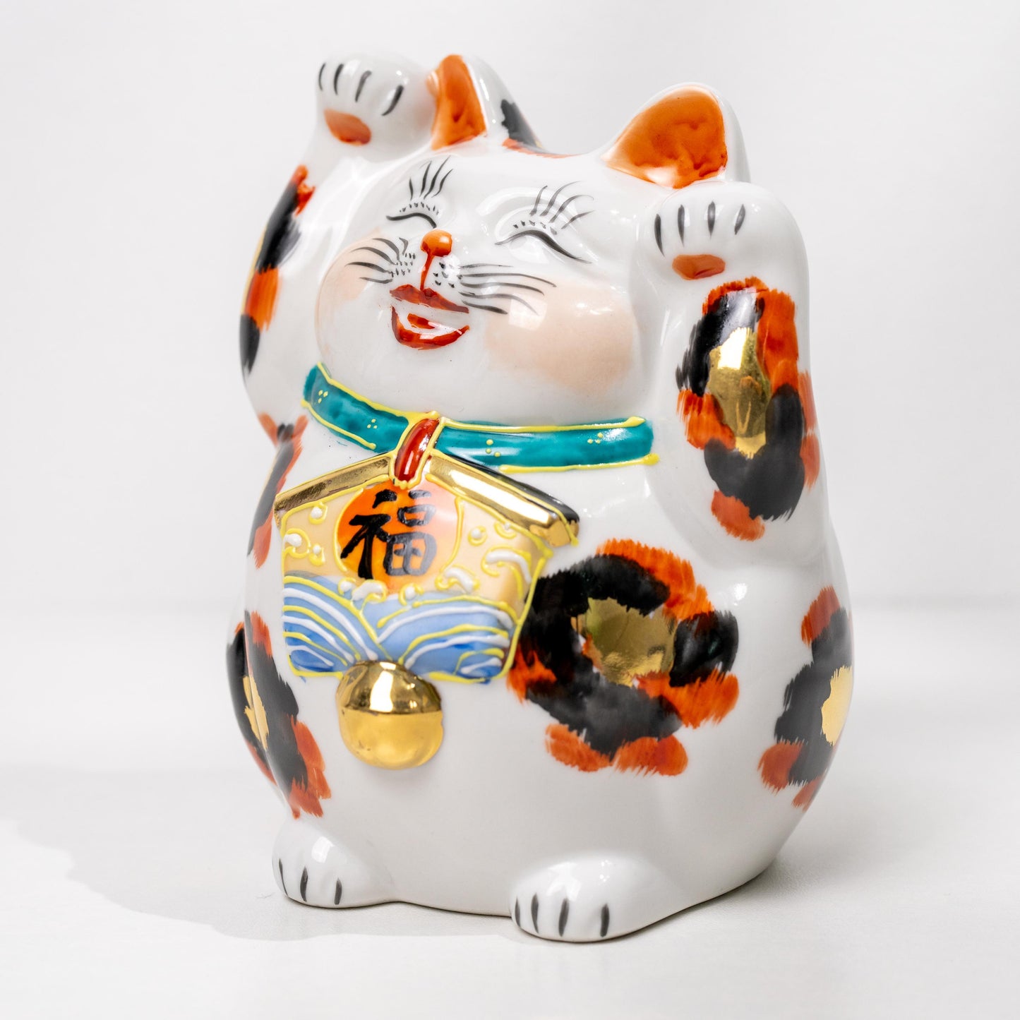 Kutani gold calico lucky cat figurine on white background
