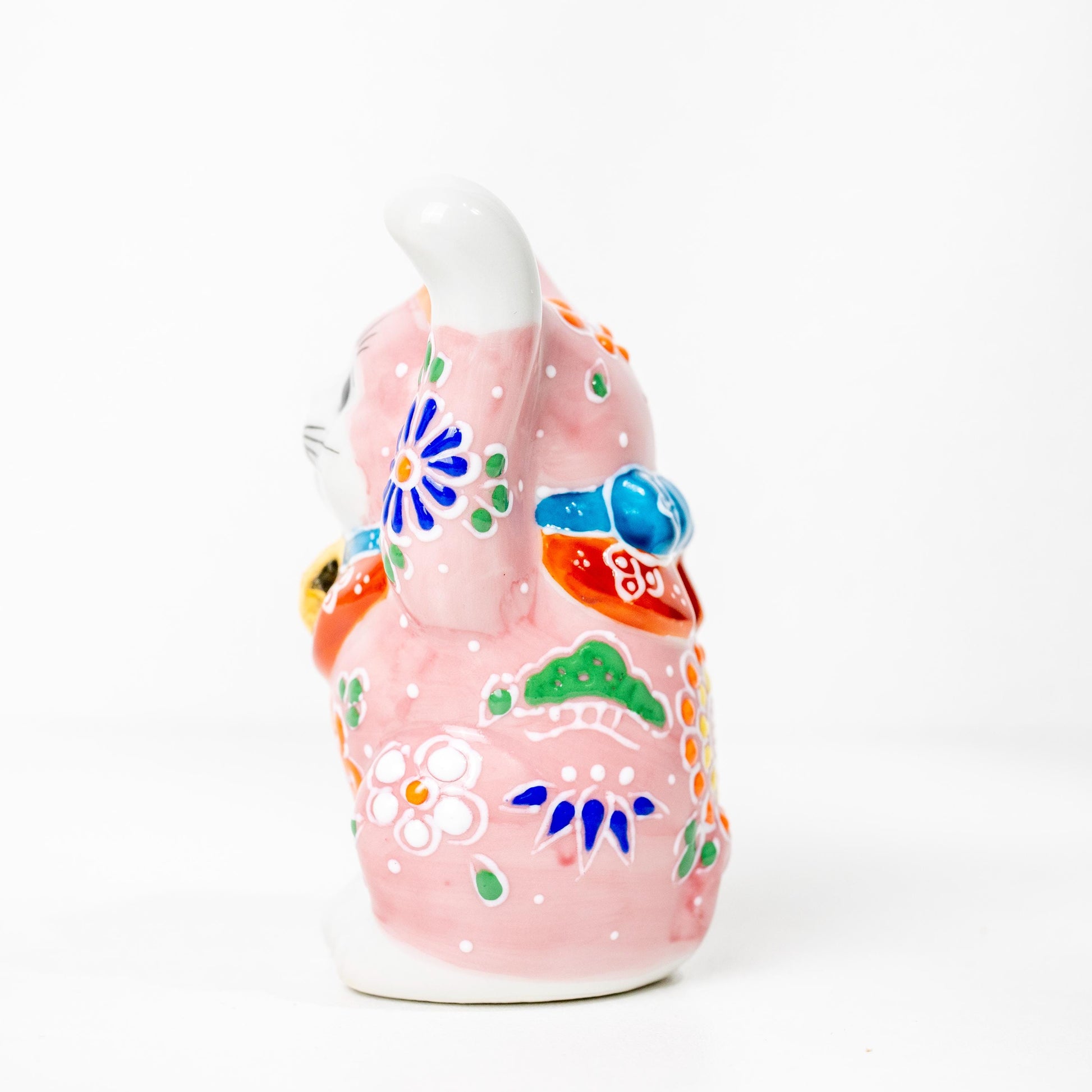 Angled view of pink lucky cat statue in porcelain