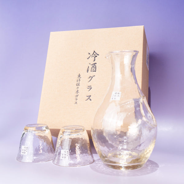 Amber glass sake set with ice pocket carafe and two cups beside gift box