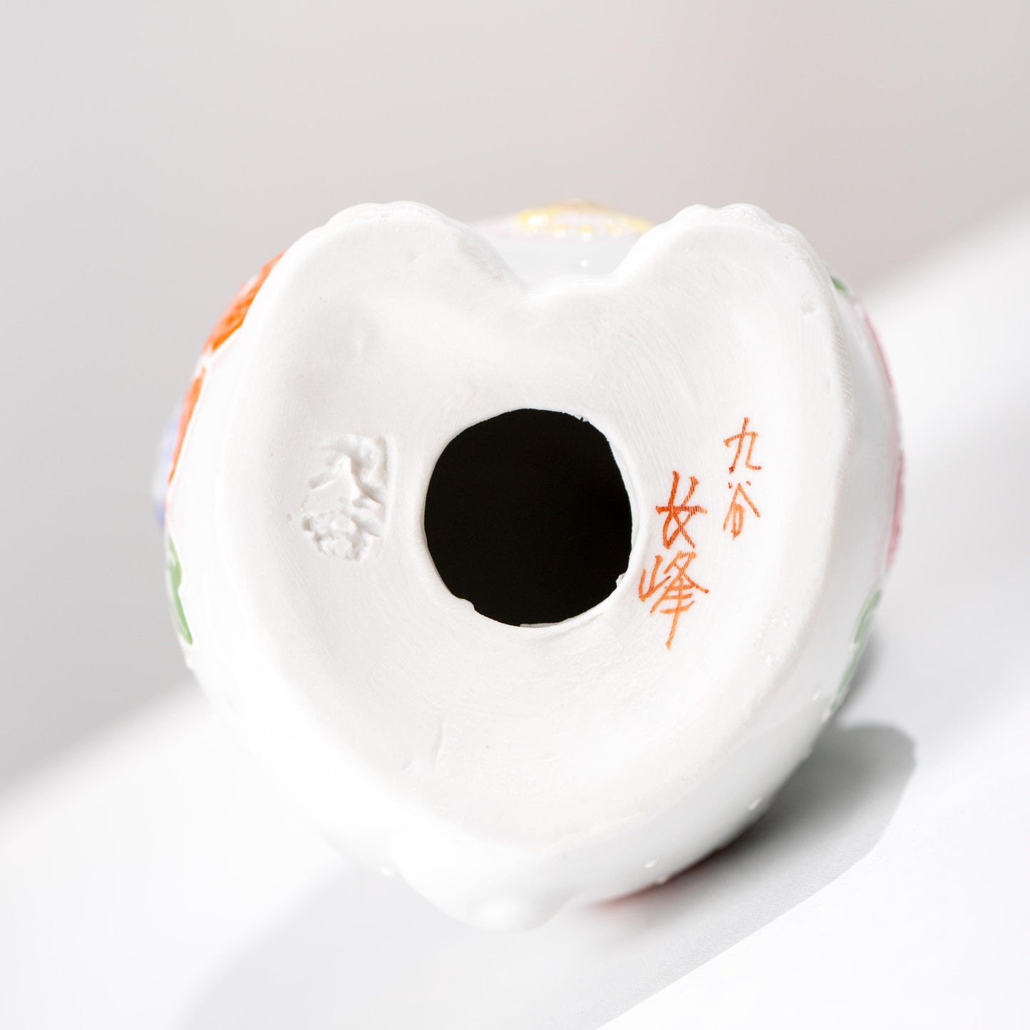 Underside of Kutani ceramic figurine showing base opening