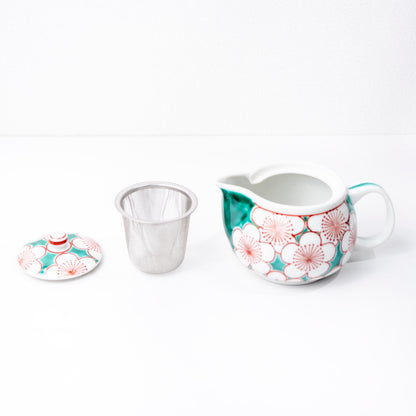 Angled view of teapot and two yunomi cups in red and blue kutani pattern