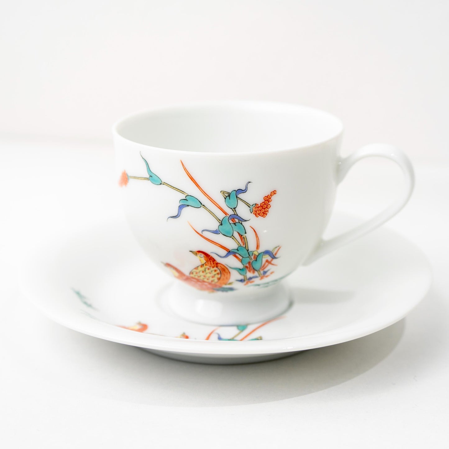 Front view of Arita quail coffee cup and saucer set on white background