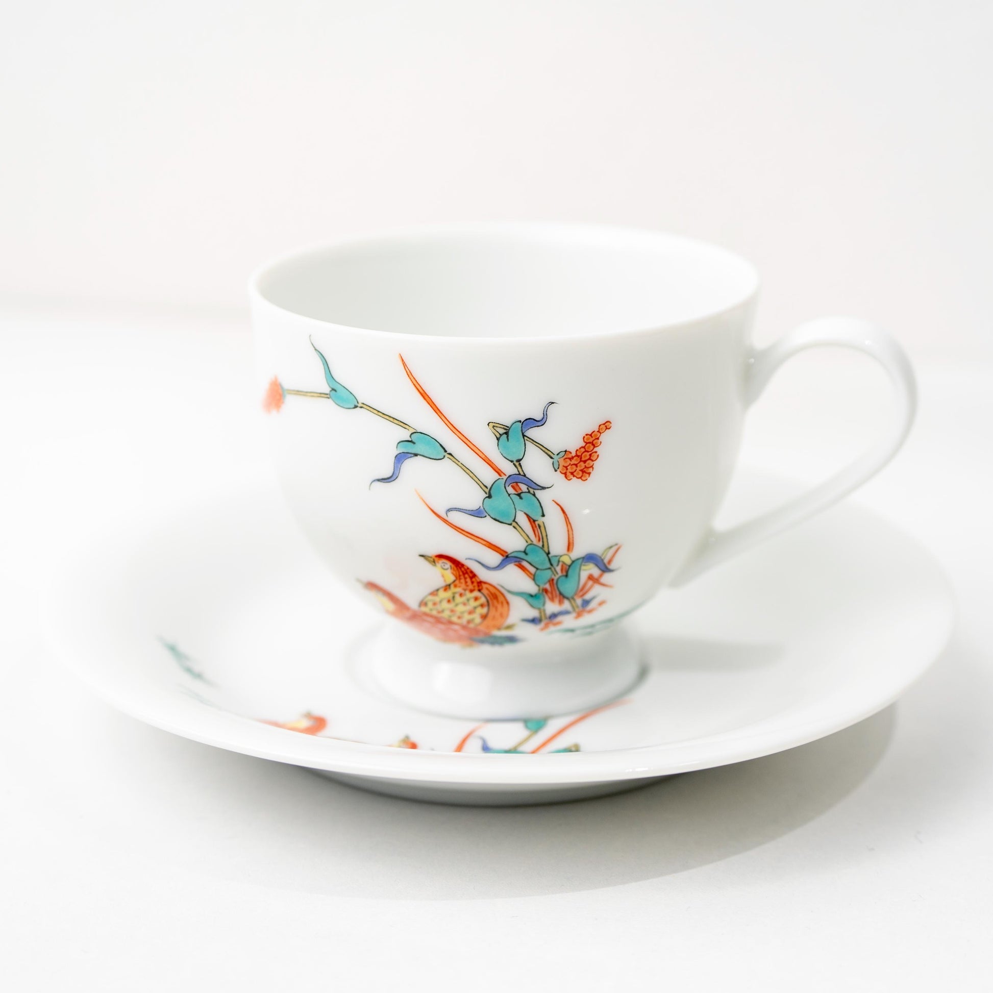 Front view of Arita quail coffee cup and saucer set on white background
