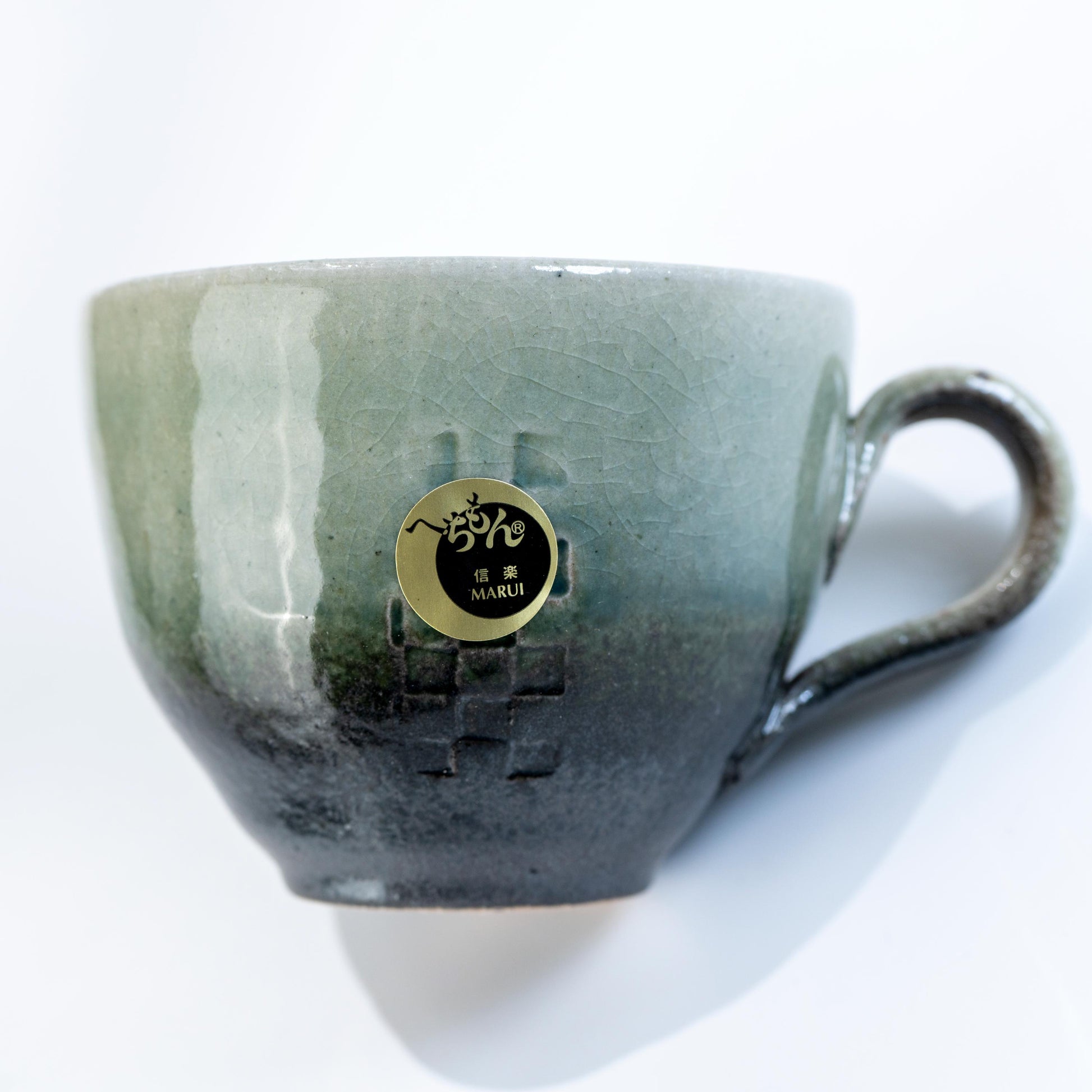 Angled view of Japanese stoneware coffee cup with handle