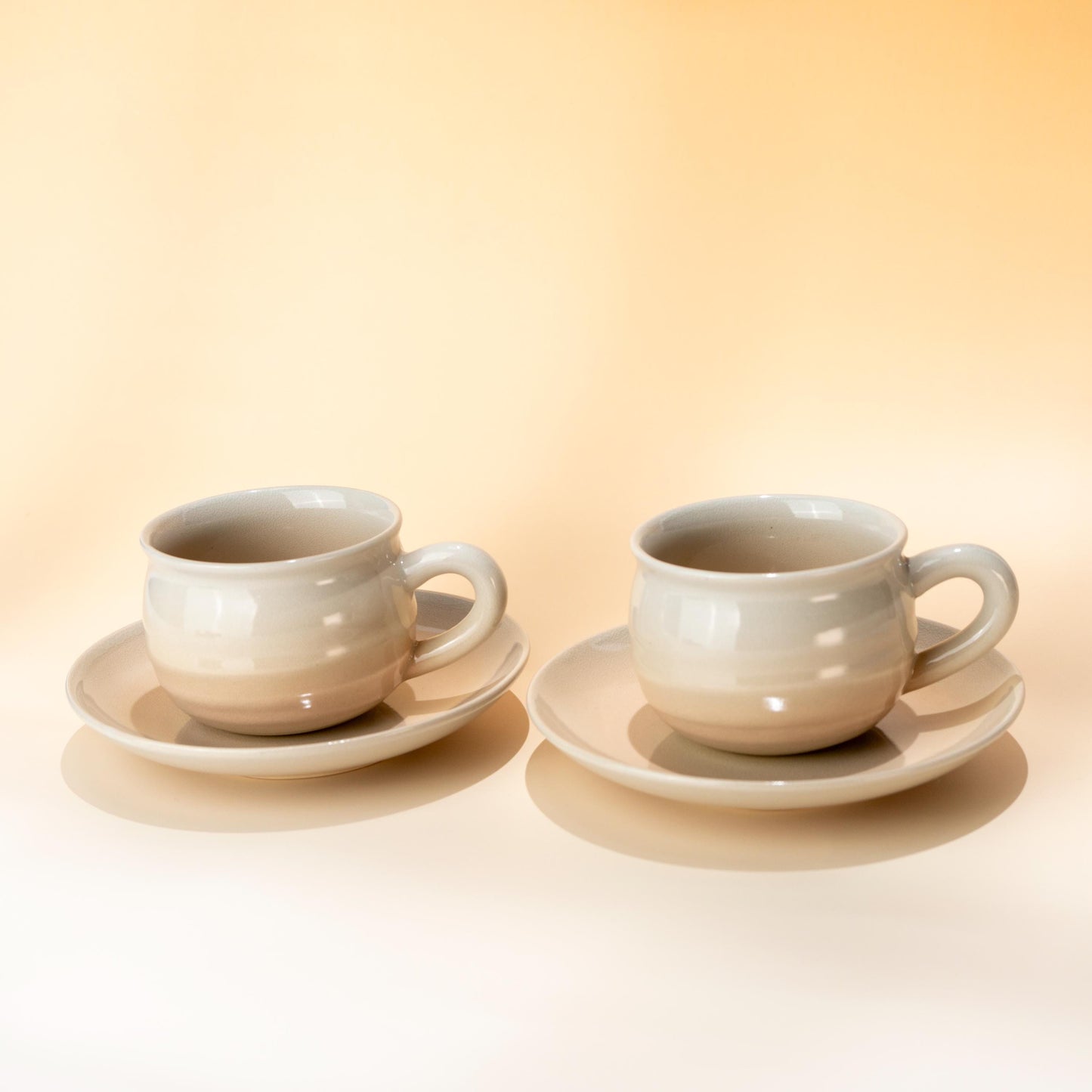 Two handmade Hagi yaki coffee cup and saucer sets in a soft blush glaze