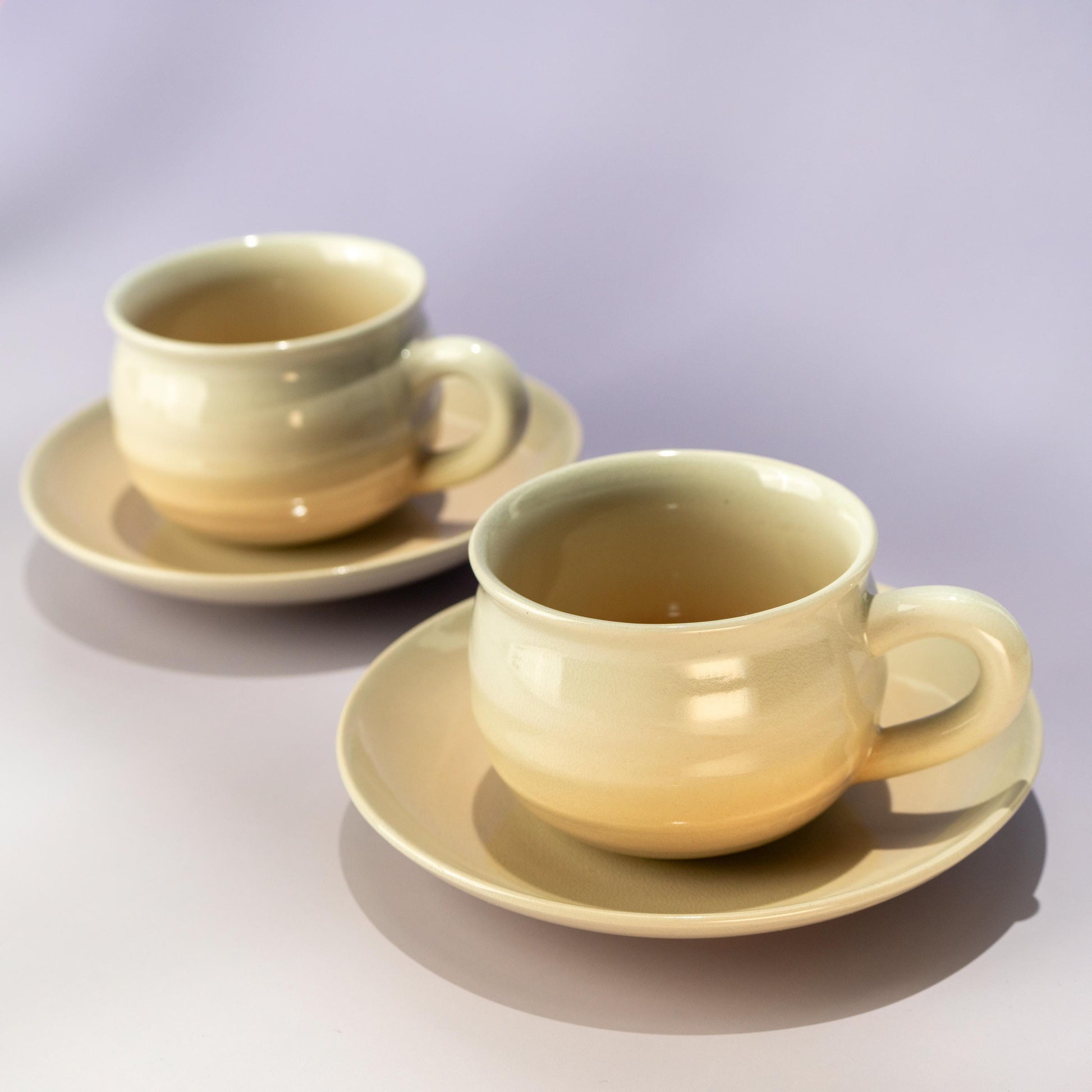 Two Hagi yaki coffee cup and saucer sets styled together on a soft background