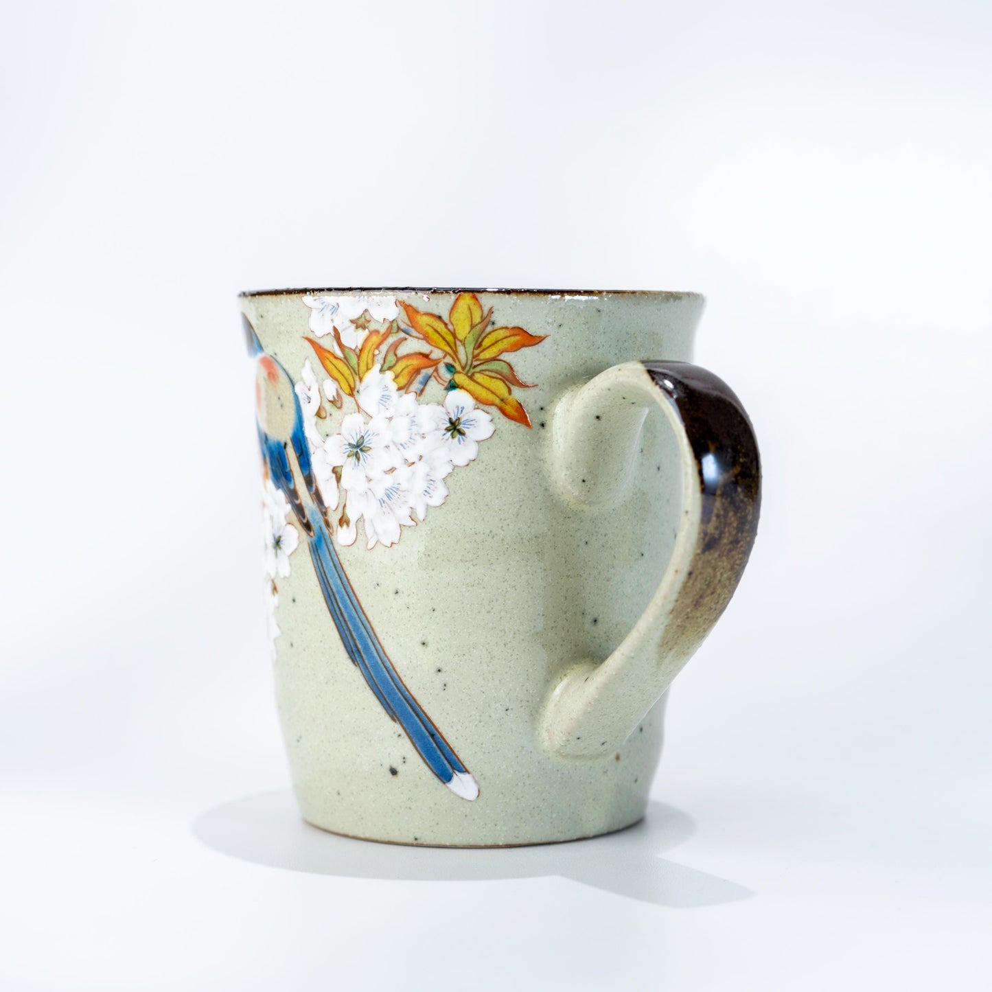 Angled view of Kutani ware bird mug with floral hand-painted detail