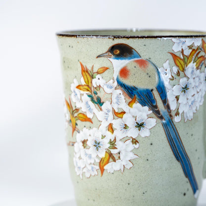Close-up of hand-painted cherry blossom and bird design on Kutani ceramic mug