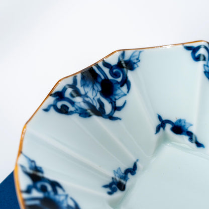 Close-up of the scalloped rim and blue arabesque detail on an Arita bowl
