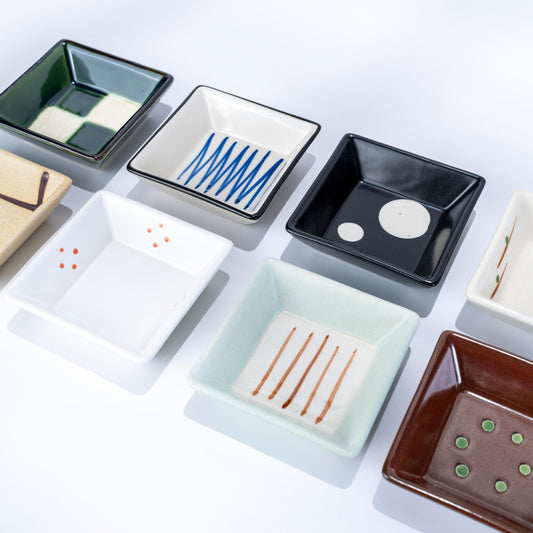 Open gift box showing eight small Japanese porcelain dishes