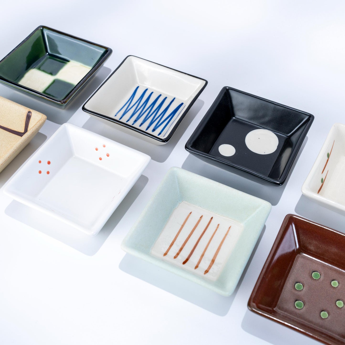 Open gift box showing eight small Japanese porcelain dishes