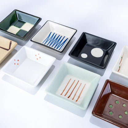 Open gift box showing eight small Japanese porcelain dishes
