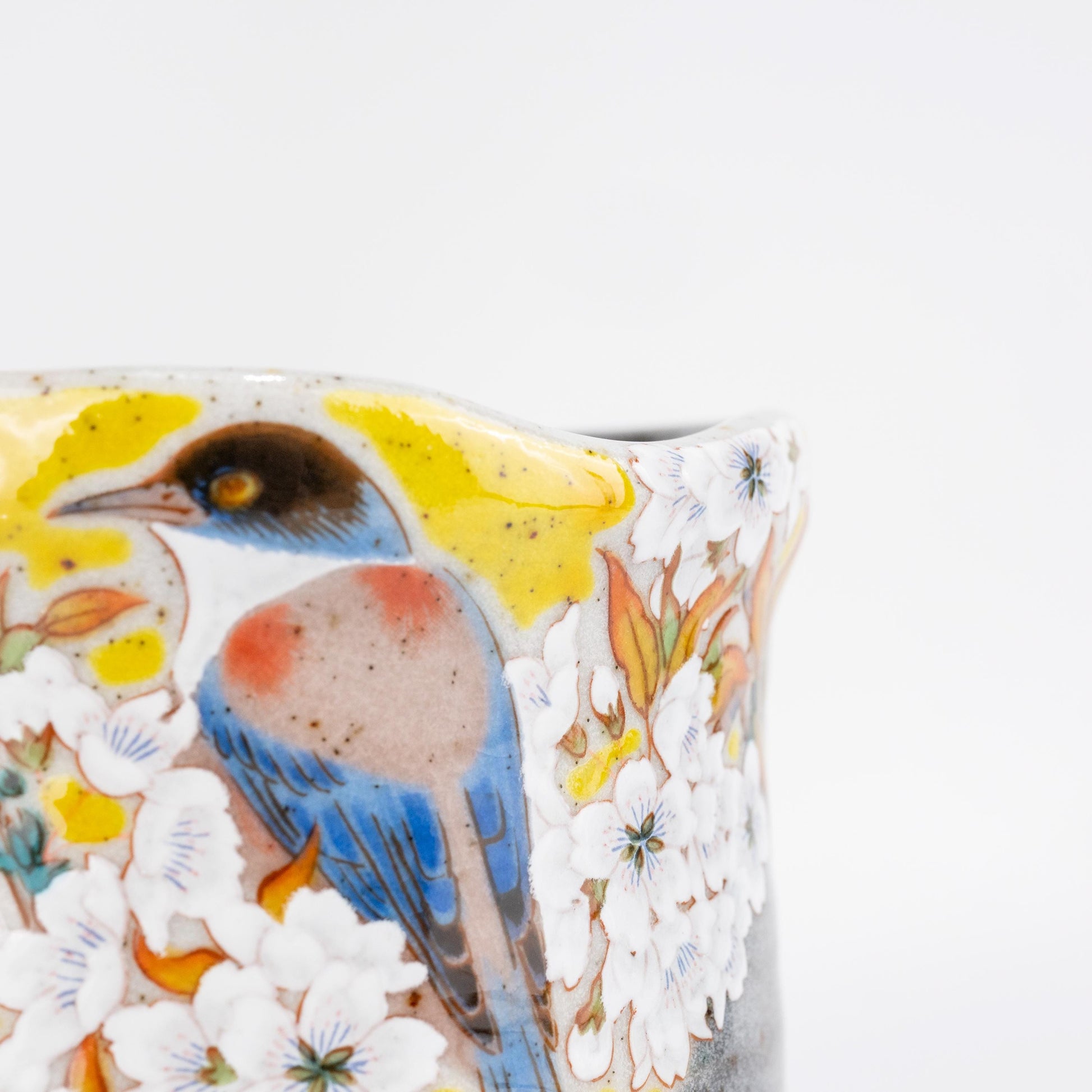 Close-up of bird and cherry blossom detail on a Kutani Yoshidaya cup