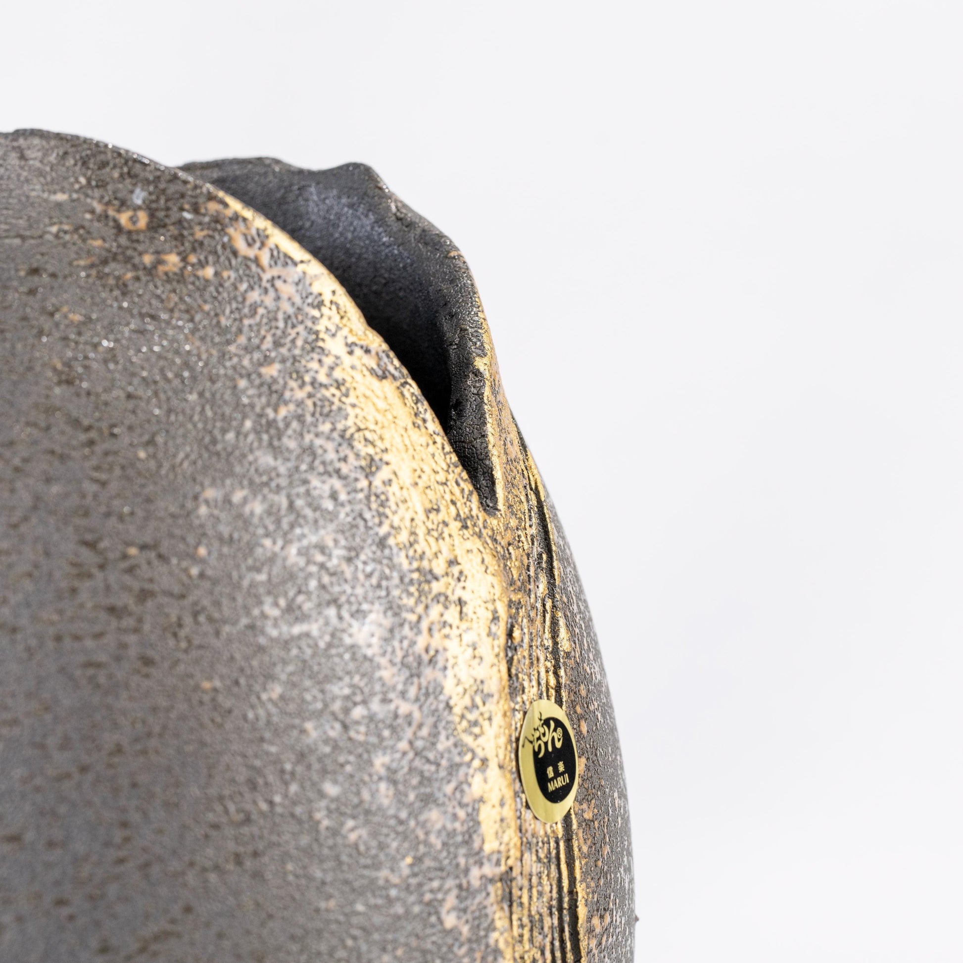 Close-up of gold brush detail on black Shigaraki vase