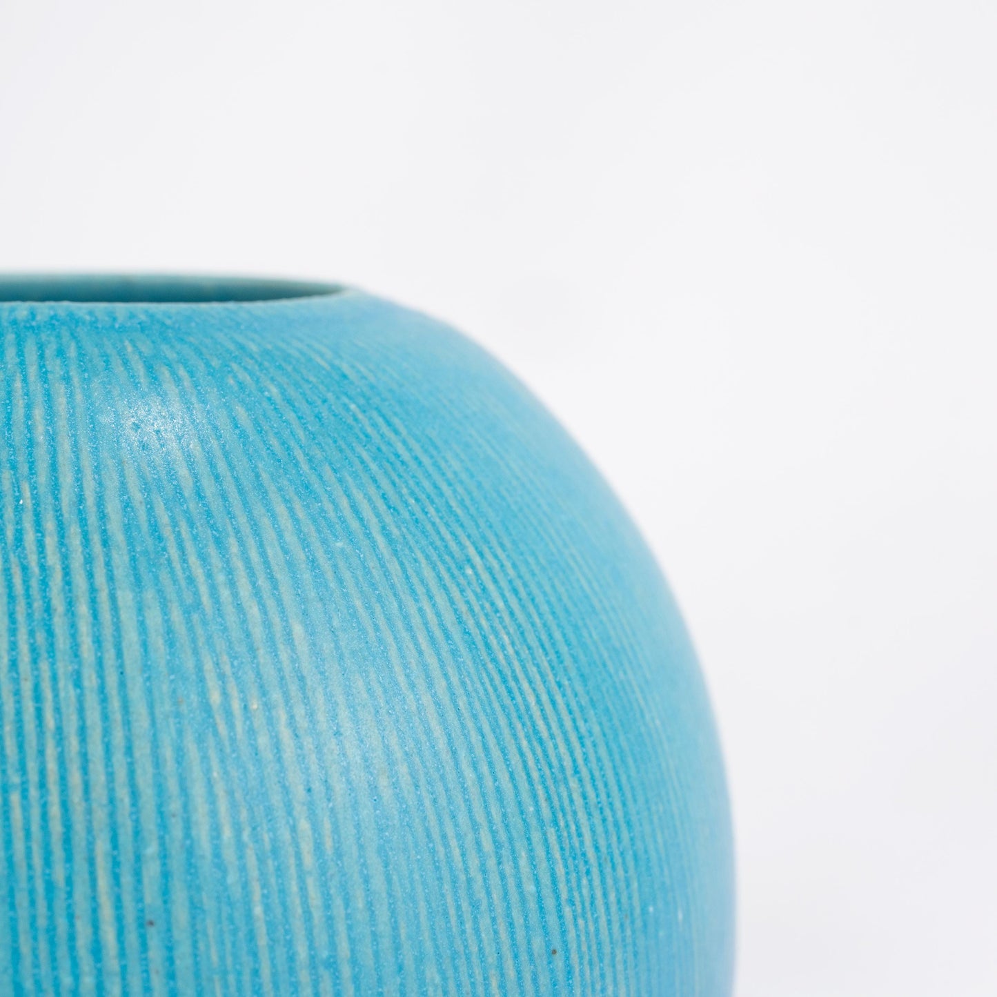 Close-up of turquoise glaze texture on a handmade Shigaraki vase