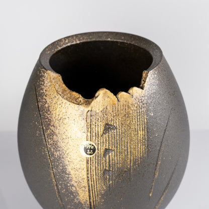 Full body view of rounded Shigaraki black gold decorative vase