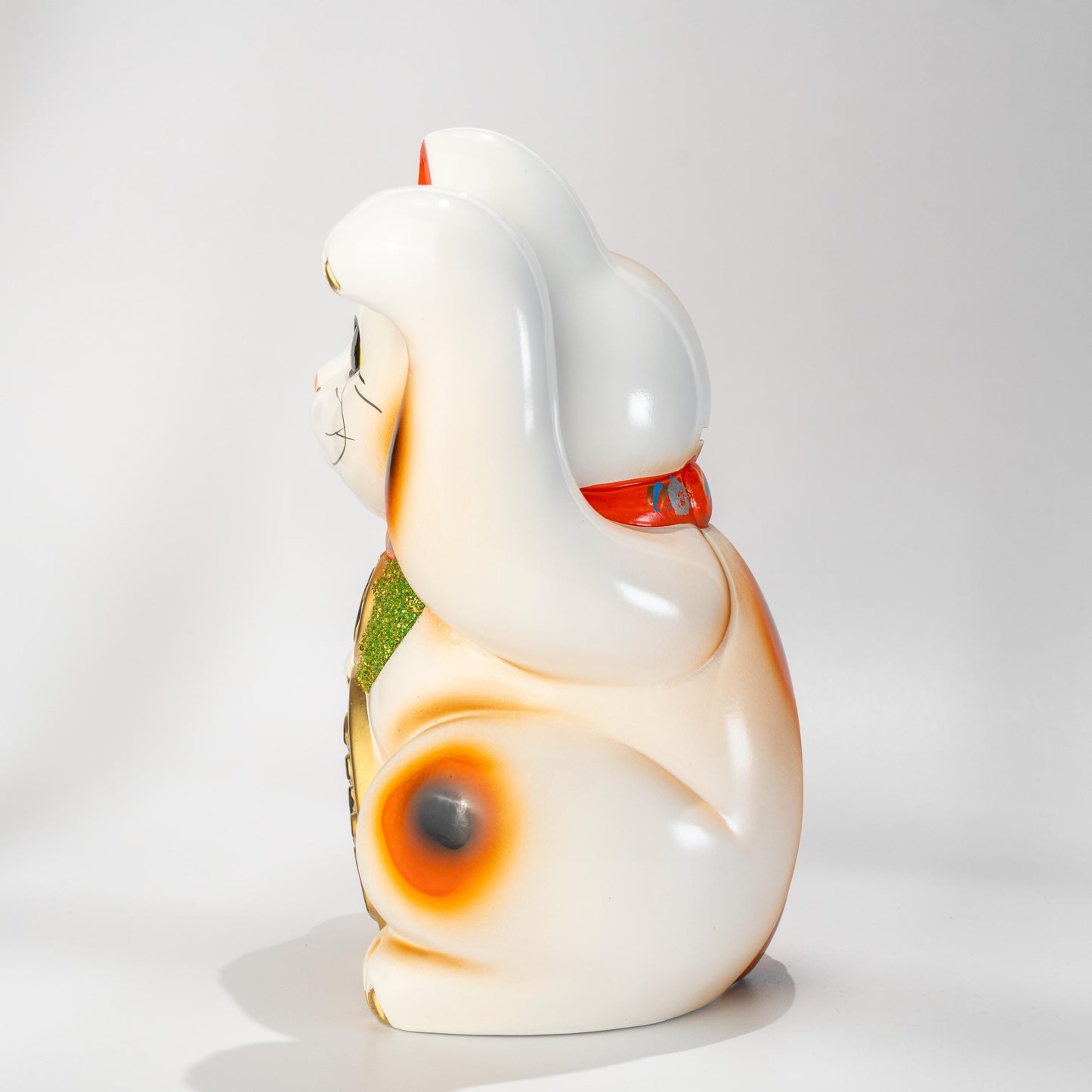 Side view of white Tokoname Maneki Neko figurine in ceramic