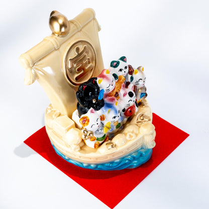 Front view of treasure ship figurine on red base cloth
