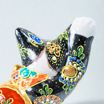 Side view of Kutani lucky cat figurine with Mount Fuji motif
