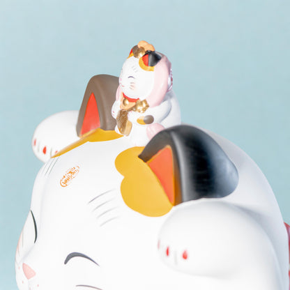 Side view of left paw lucky cat statue in ceramic