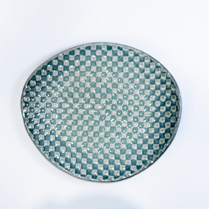 Close-up of saucer surface in olive green mosaic glaze