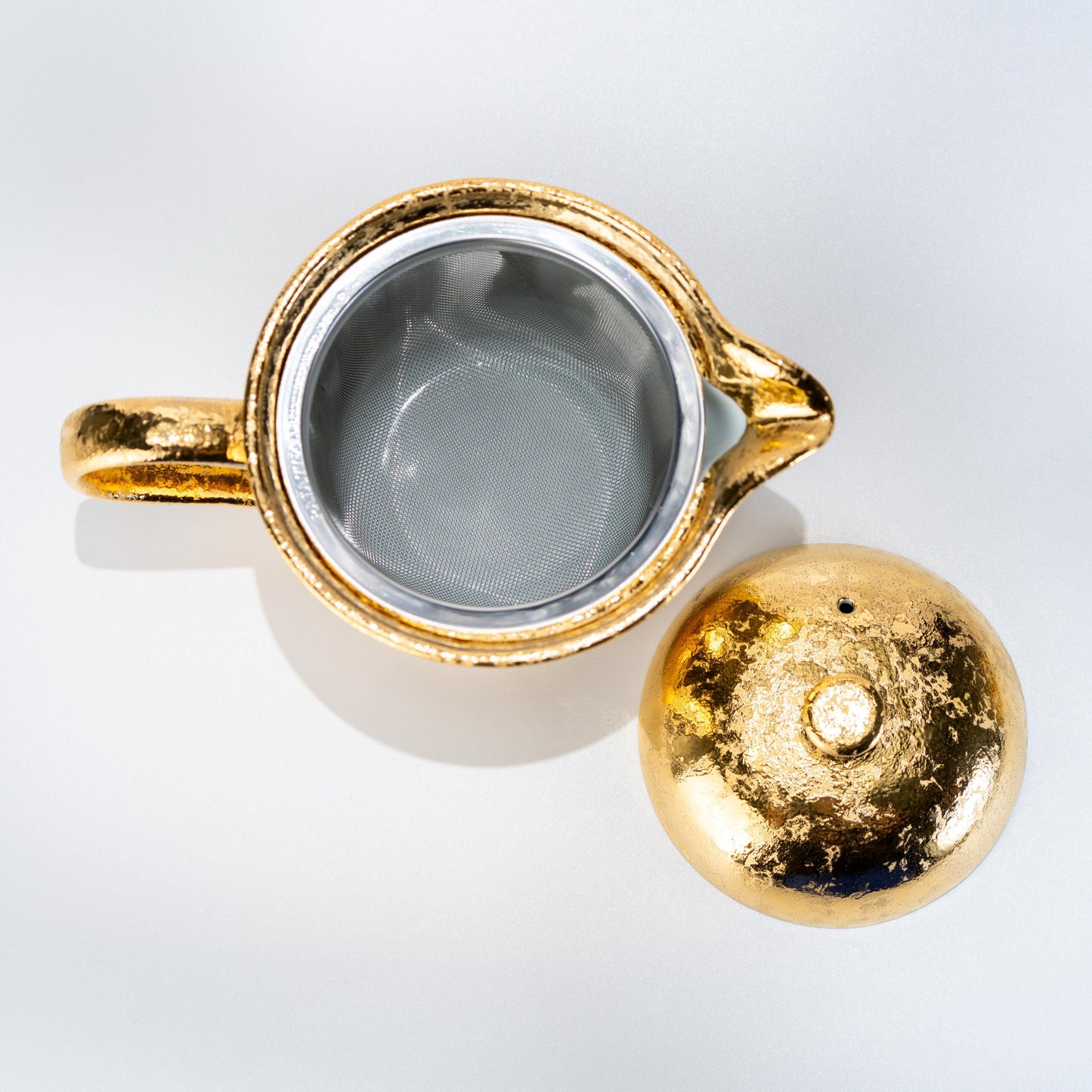Top opening of gold glazed teapot showing inner strainer area