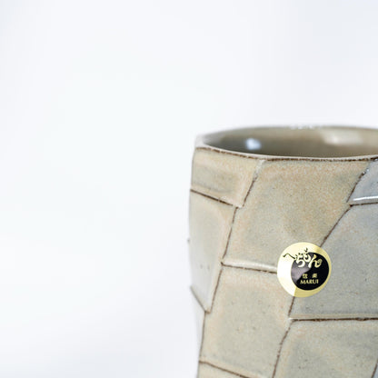 Angled view of handmade greige mug in Japanese pottery
