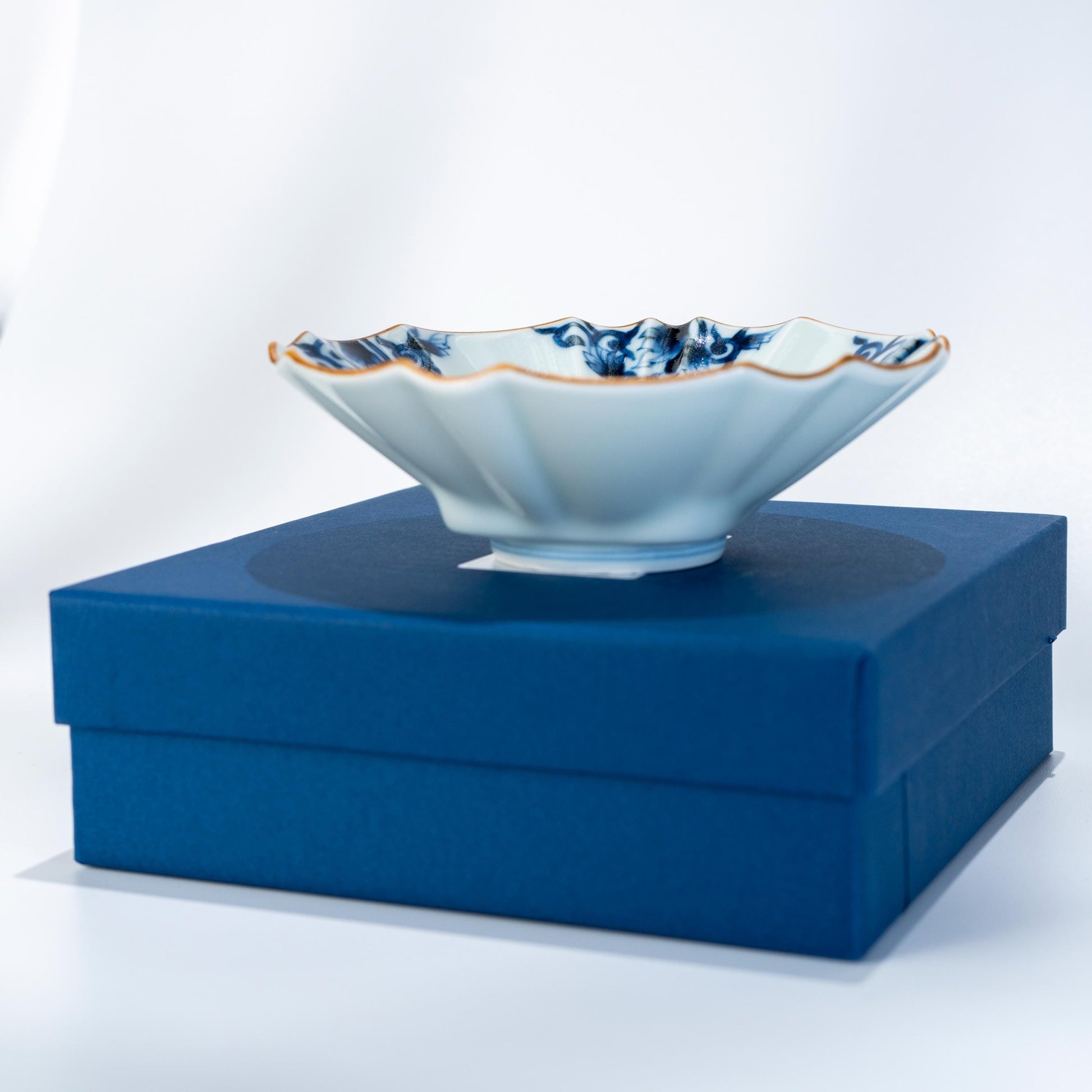 Arita ware blue arabesque bowl displayed on a blue presentation box