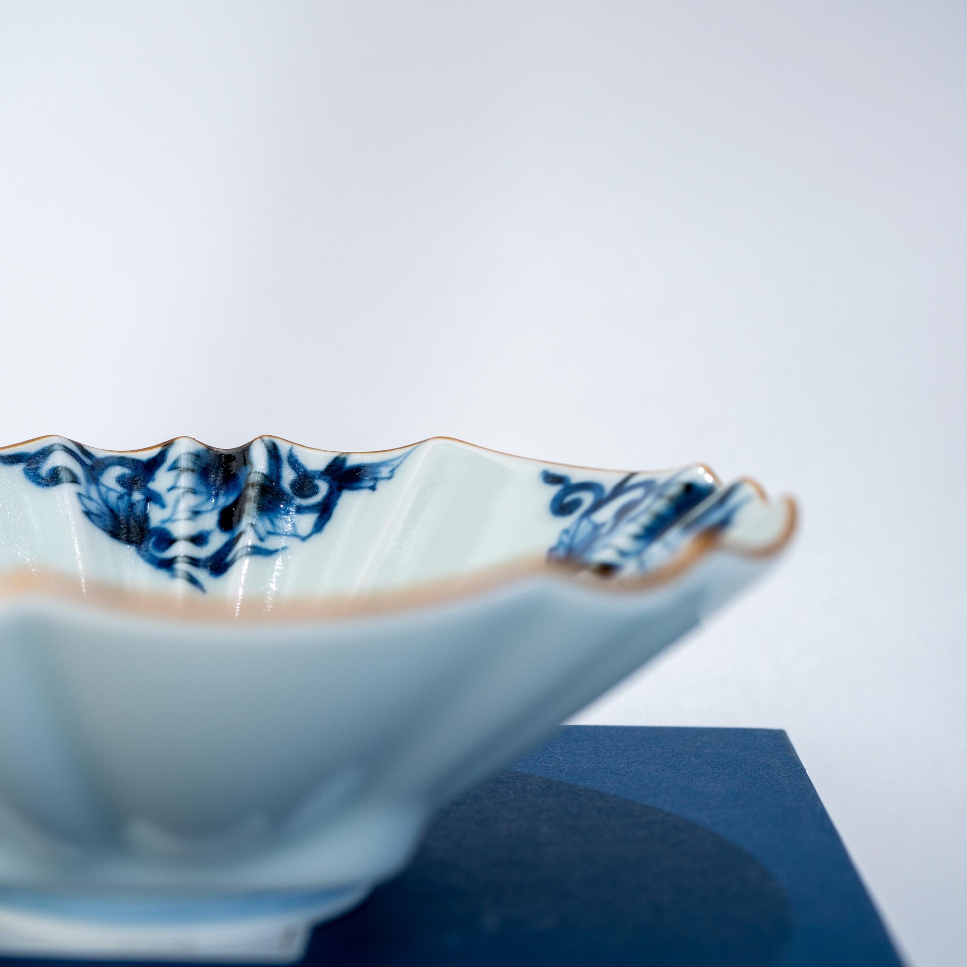 Side profile of Arita ware blue arabesque bowl with sculpted rim