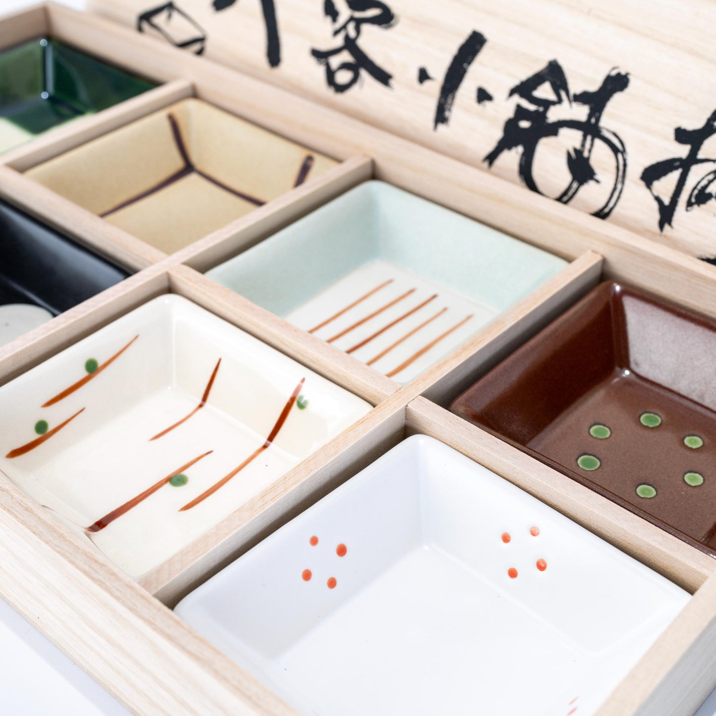 Top view of square dish set arranged in wooden gift box