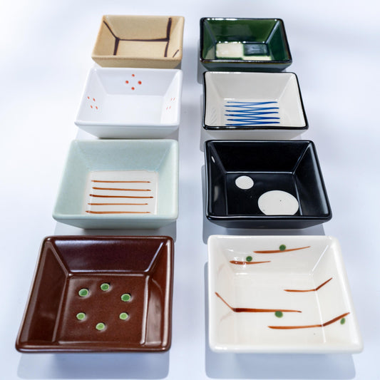 Open wooden box with assorted square porcelain dishes from Awasaka