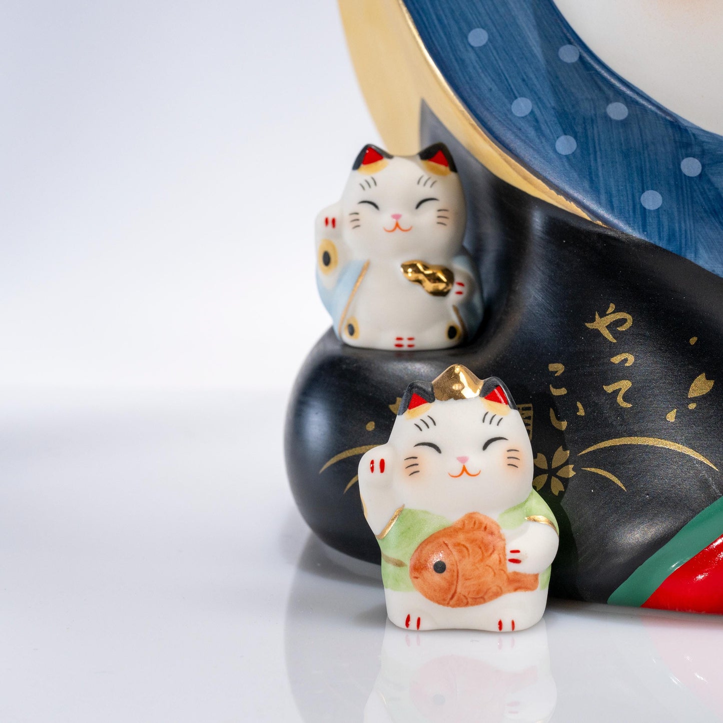 Close-up of the face and raised paw on a large maneki neko statue