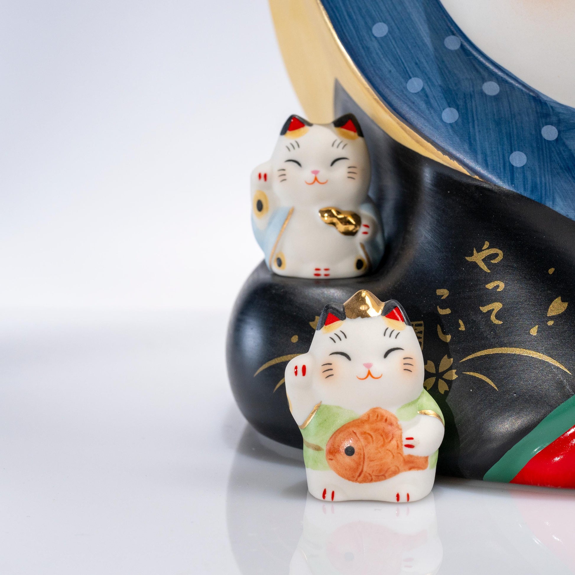Close-up of the face and raised paw on a large maneki neko statue